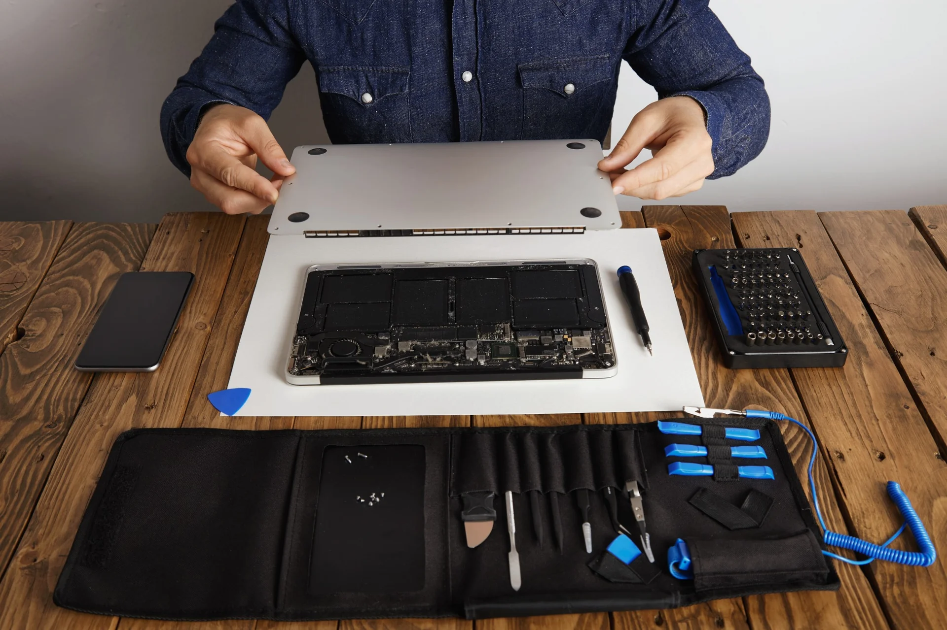 Technician repairing iPhone screen with precision tools